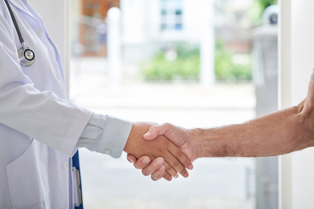 Doctor welcoming a new patient with a handshake at Helderberg Family Practice in Somerset West.