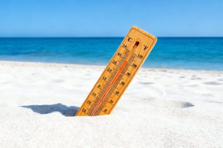 Thermometer in hot sand on a Somerset West beach symbolising a summer heatwave.